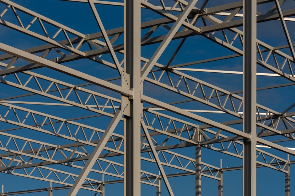 Steel framework trusses under blue sky during custom metal building construction in Jonesville, NC